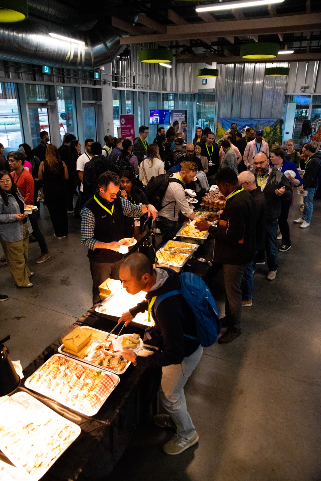 Guests at a corporate event lining up along a BRDGE buffet, seen from above